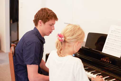 Child learning to play paino.
